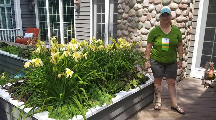 Woman standing next to a planter full of yellow daylilies