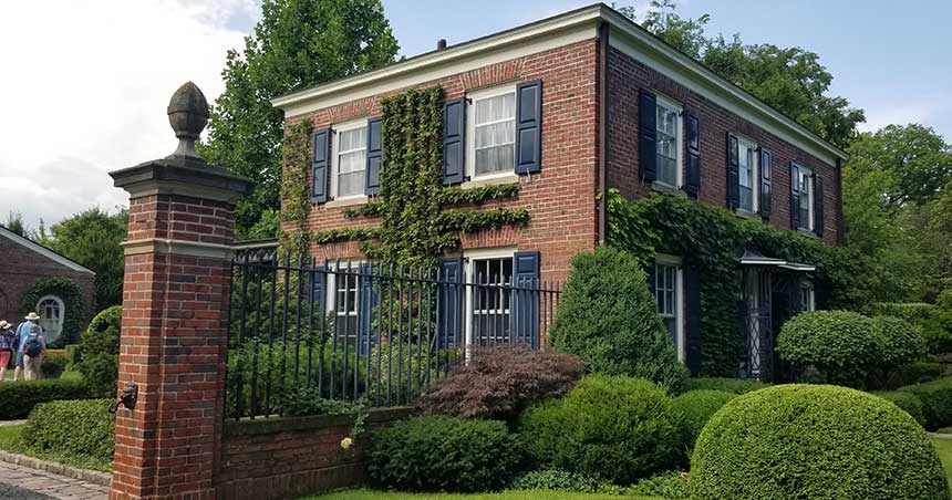 Brick house and gate, set in a garden setting