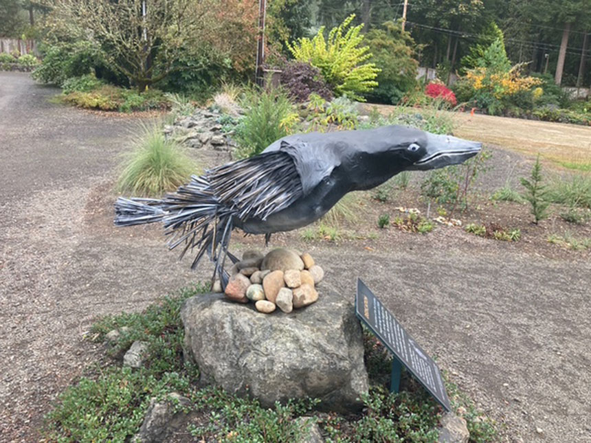 metal sculpture on rock,	Raven Sculpture by Debby Purser