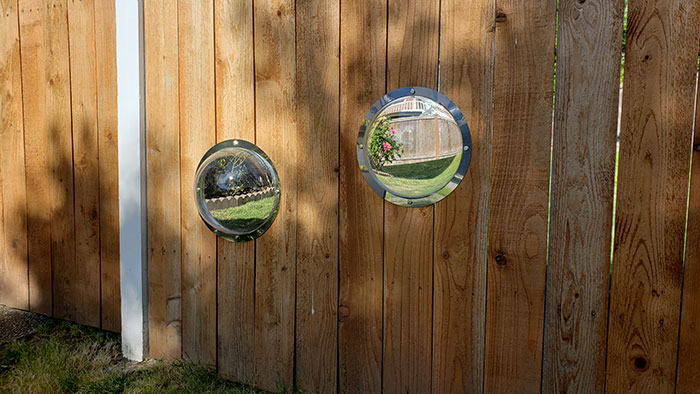 wooden fence with two circular windows at varied heights.