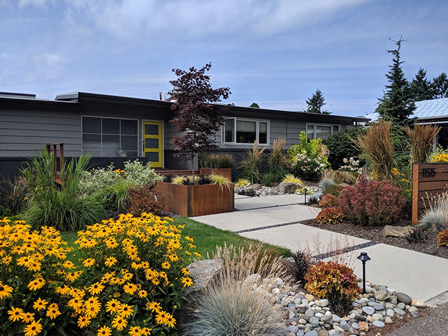 Front of home showing flowers, walk way, planter boxes, garden lights and lawn