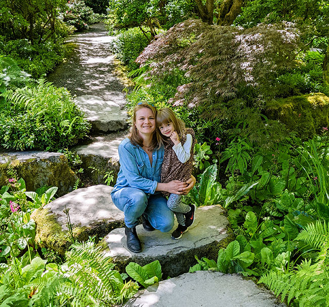 Jade Waples poses with her daughter among boulders and perennials at Bellevue Botanical Garden