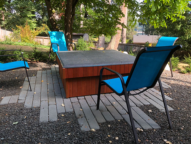 custom garden table with seats and paving